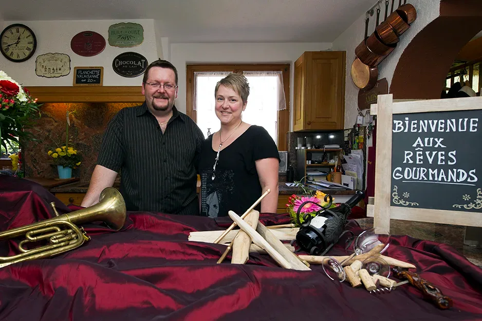 Bob and Cécile portrait in their dining room with traditional décor, embodying the personal warmth and authenticity of the hosts.