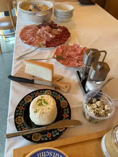 Artisan cheese, cured meats, and fresh spreads on a breakfast buffet table, highlighting the local and authentic culinary offerings of the B&B.