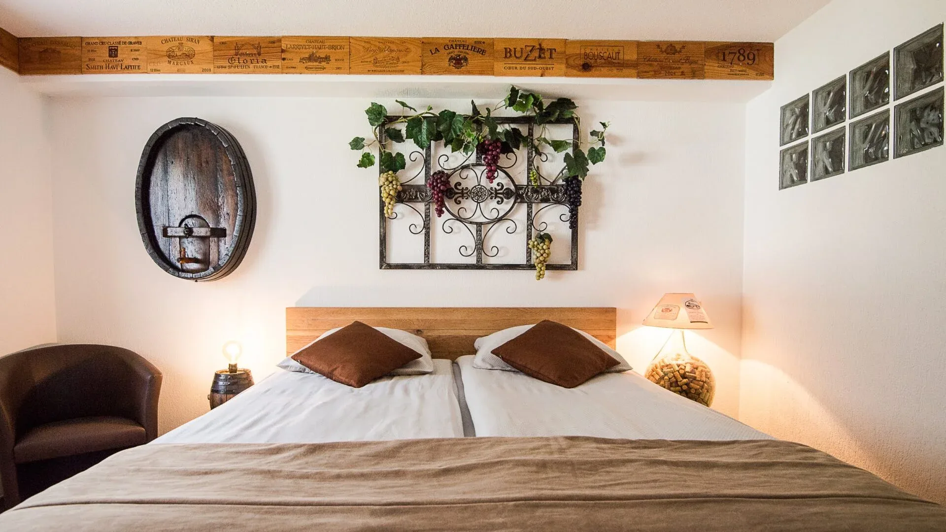 Tastefully decorated bedroom with vineyard-themed wall art and warm lighting, exemplifying intimate comfort and attention to detail.