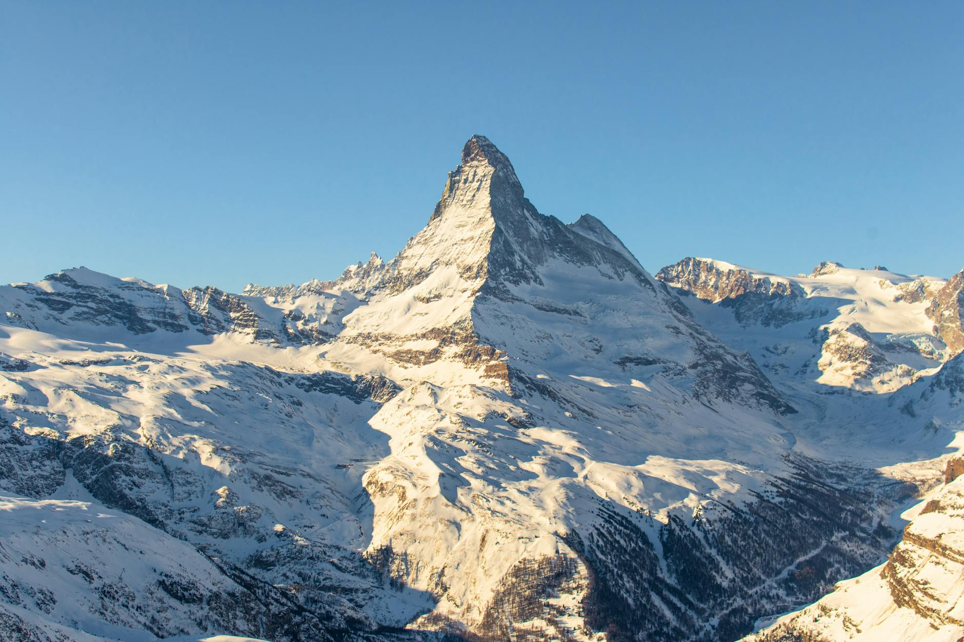 Ein luxuriöses Schweizer Hotel mit atemberaubender Aussicht auf die Alpen, umgeben von schneebedeckten Bergen und grüner Landschaft, das Exzellenz und Schweizer Gastfreundschaft verkörpert.