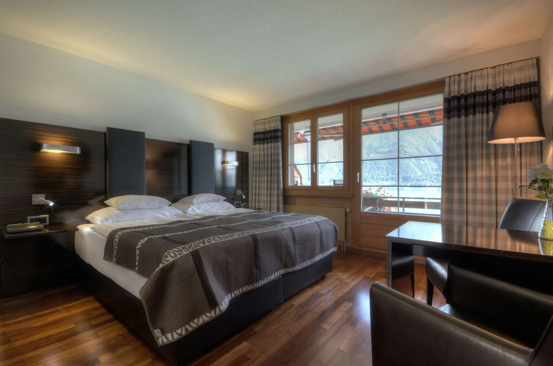 Private balcony with lounge chairs overlooking the vivid turquoise lake and dramatic mountain backdrop.