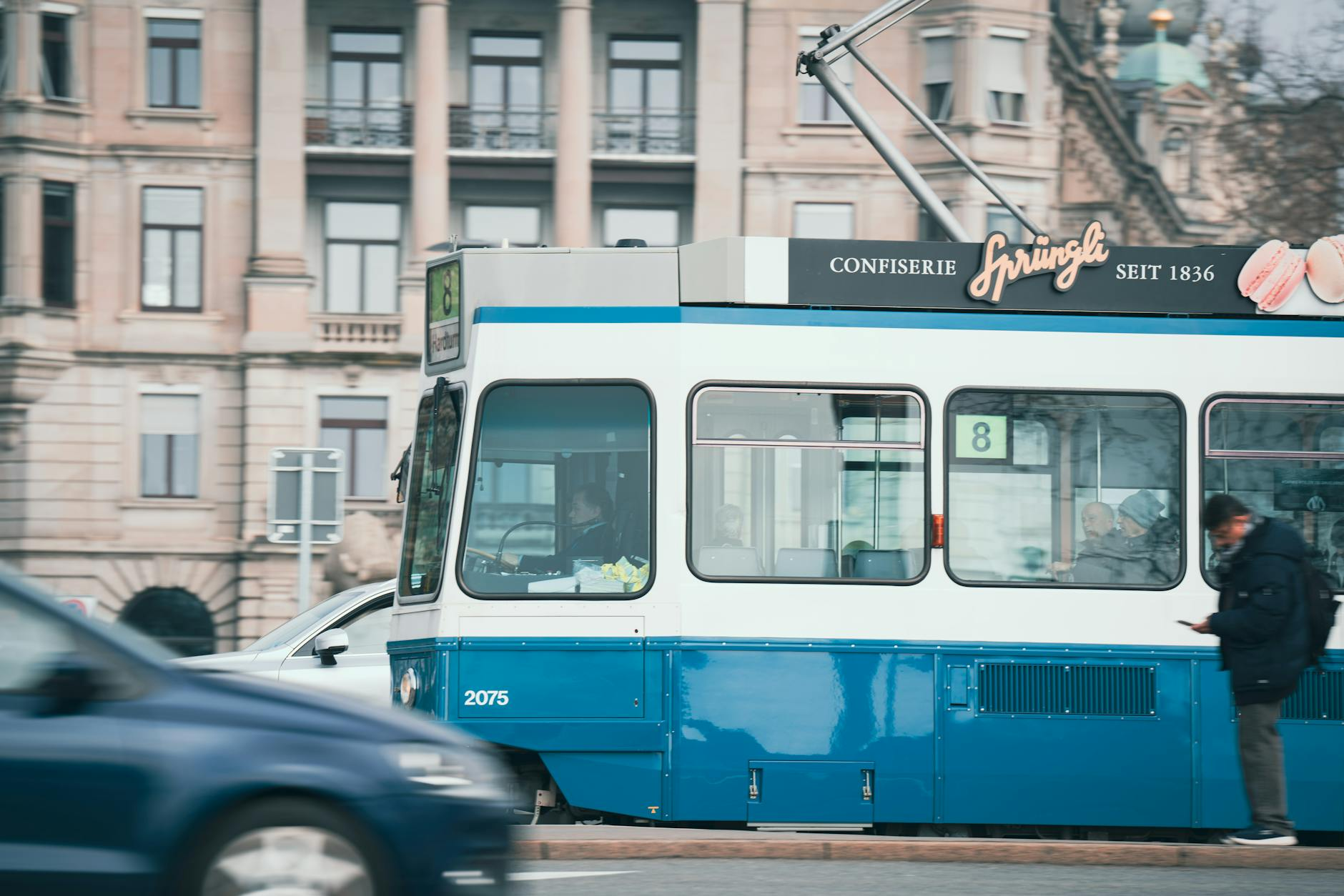Eine Reisende hält einen Lucerne Travel Pass in der Hand vor der Kulisse eines Schweizer Bergzugs und eines Sees, symbolisiert die einfache Mobilität in der Zentralschweiz.