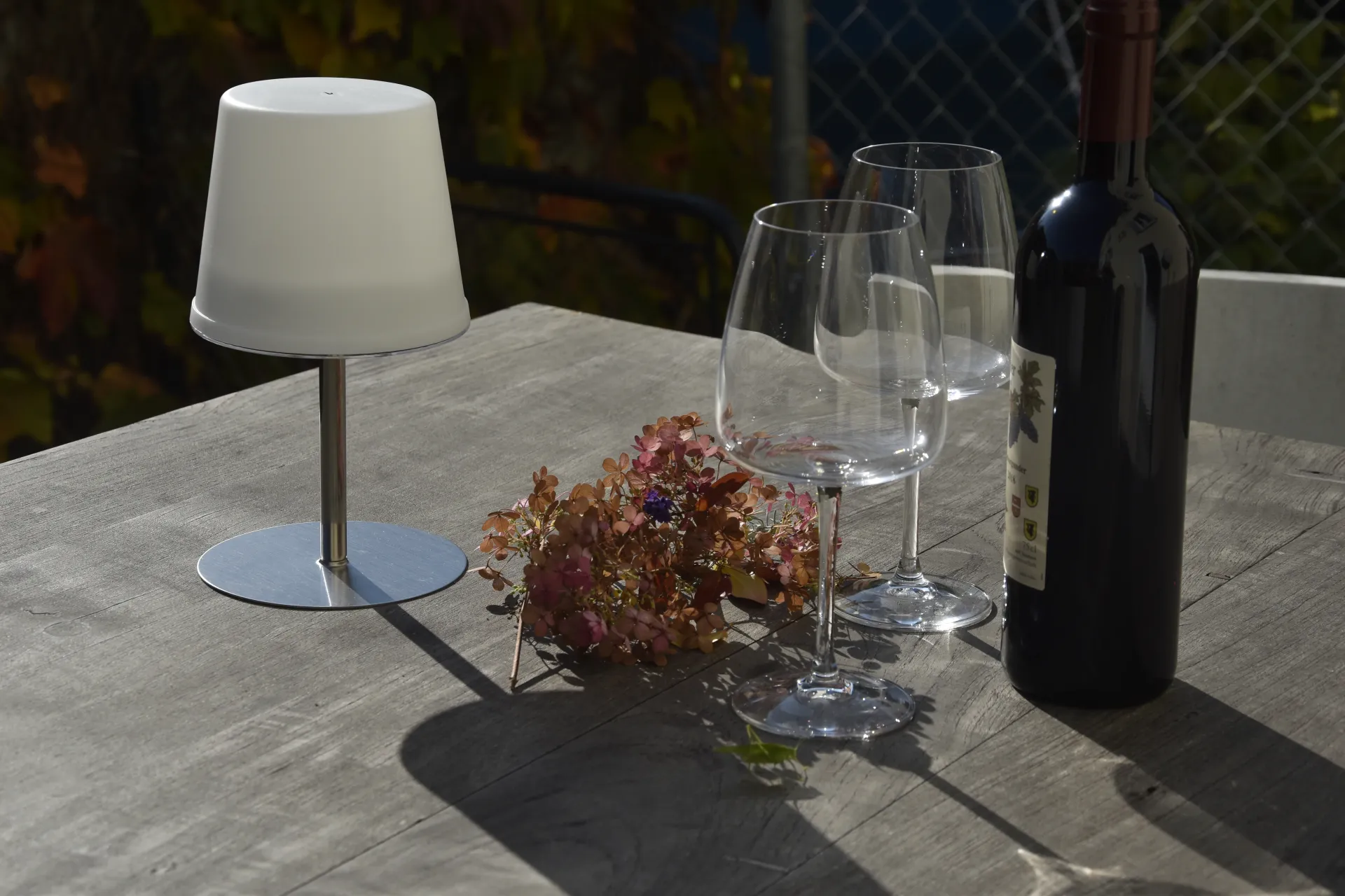 Elegant outdoor dining setup with wine and mountain backdrop, capturing the refined hospitality and regional setting of Flüh.