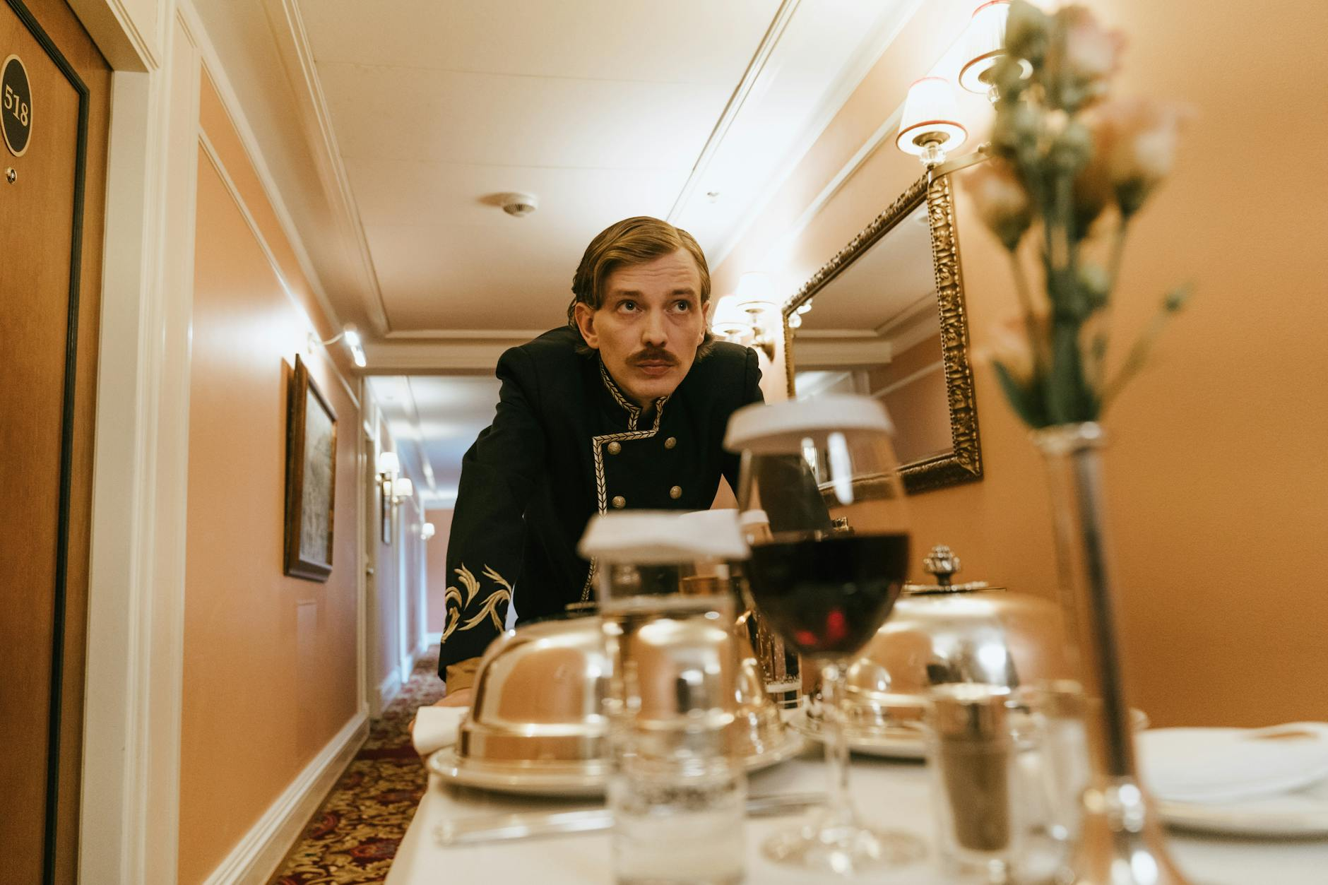 Ein elegantes Hotelrezeption in der Schweiz mit freundlichem Personal im Gespräch mit Gästen, im Hintergrund diskrete digitale Bildschirme.